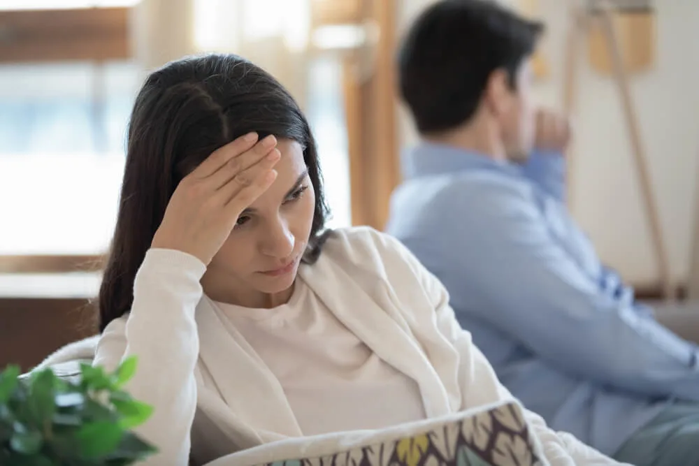 Too far from one another. Nervous angry young couple sitting on opposite