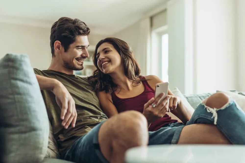 Loving couple sitting on sofa at home