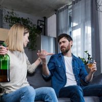 Woman telling husband to stop drinking alcohol