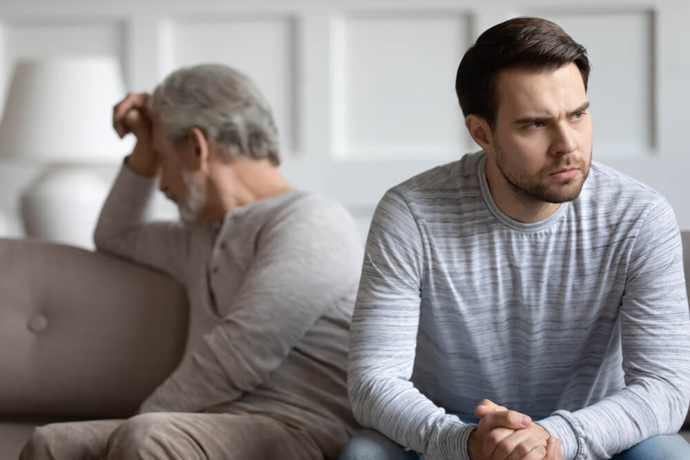 Mad thoughtful young man sit separately having fight misunderstanding with elderly father,