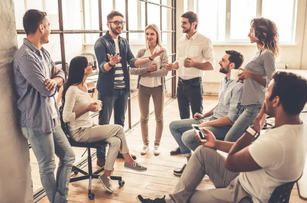 Successful young business people are talking and smiling during the coffee break in office