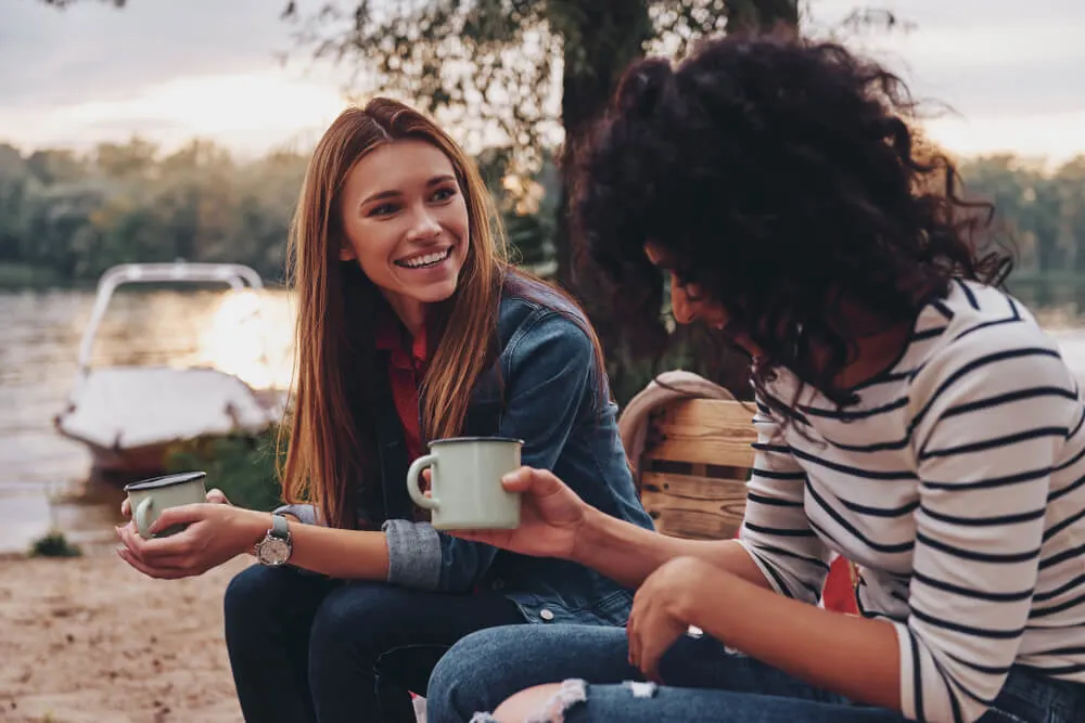 girl talking and drink coffee on the river