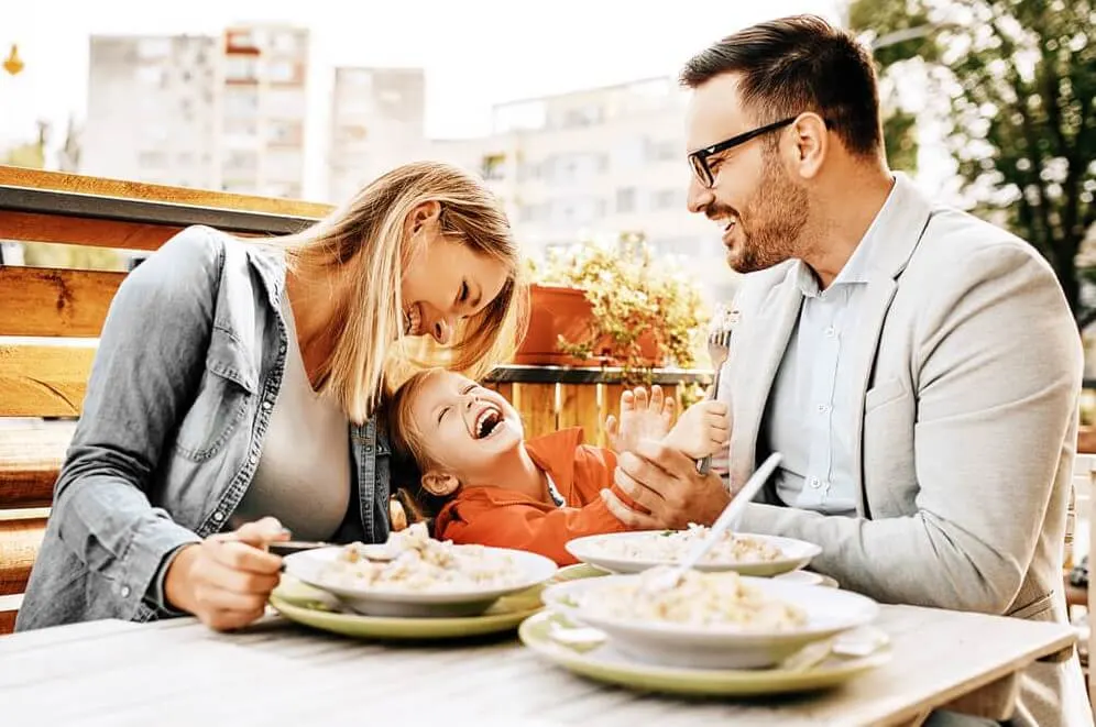 Couple laught with kid in restaurant