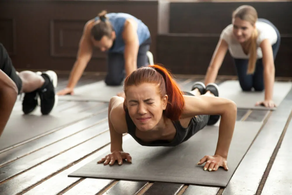 Young fit sporty woman with painful face expression