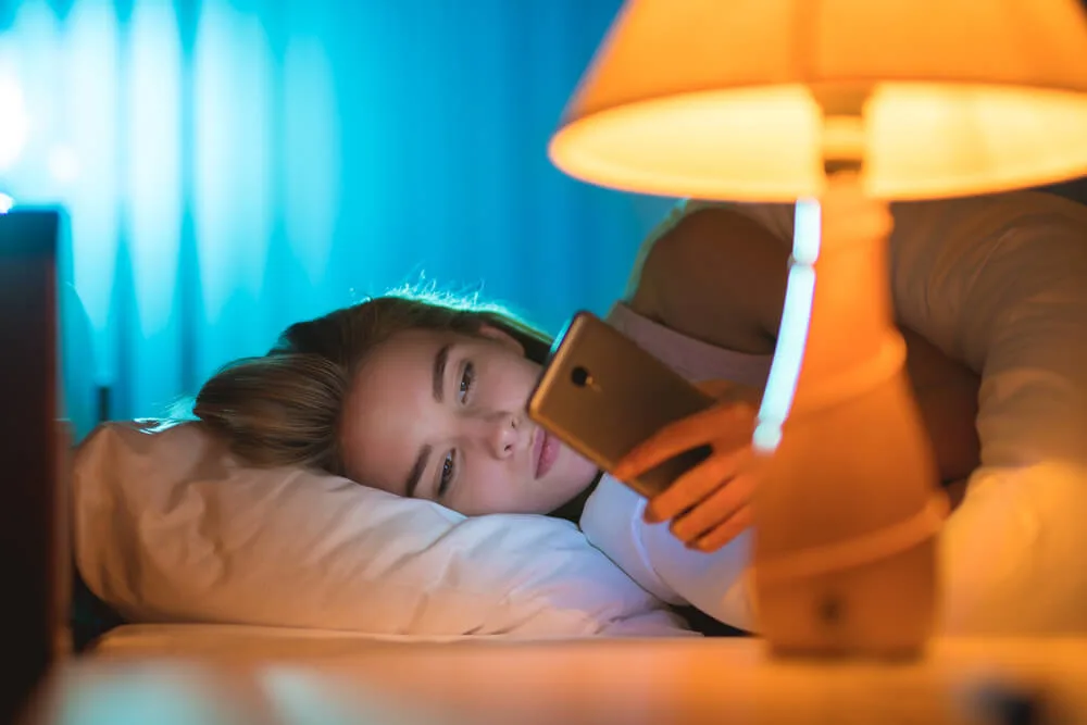 GIrl lie on the bed and using social media