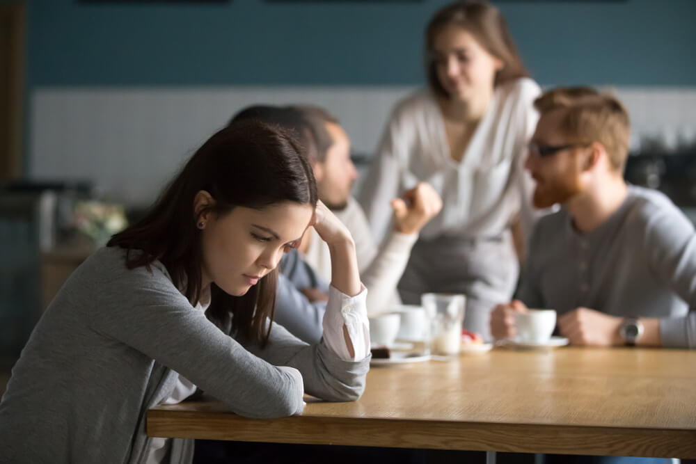 Upset young girl sit alone at coffee table in café feeling lonely or offended