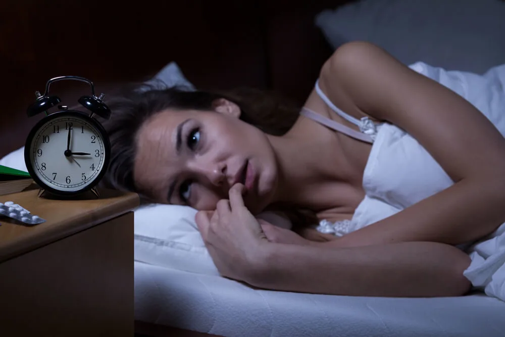 Woman lying in bed sleepless at night