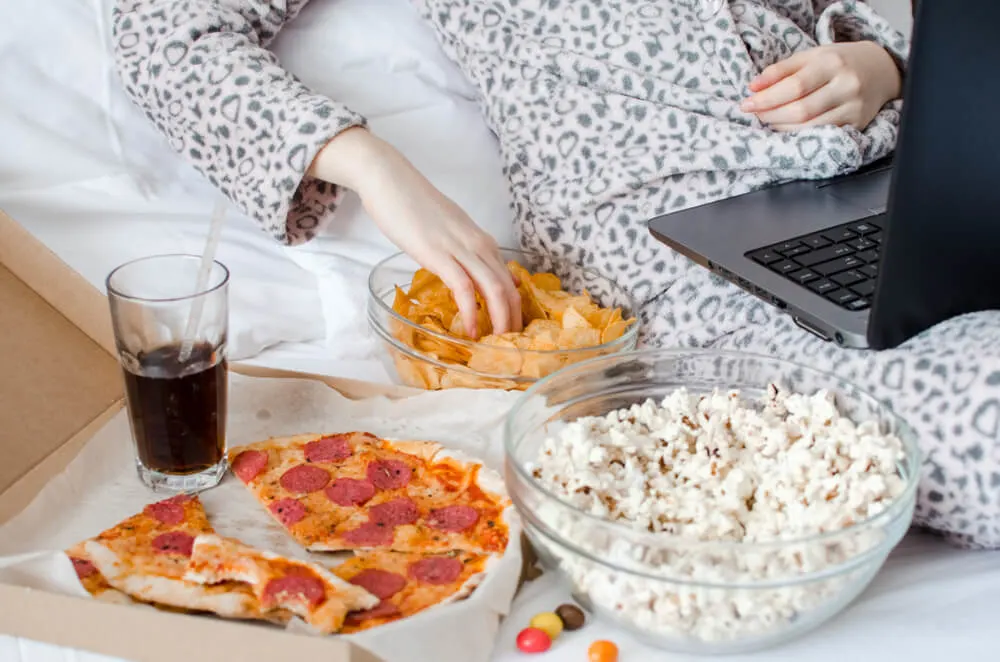 Unrecognized woman eating unhealthy food and crying.