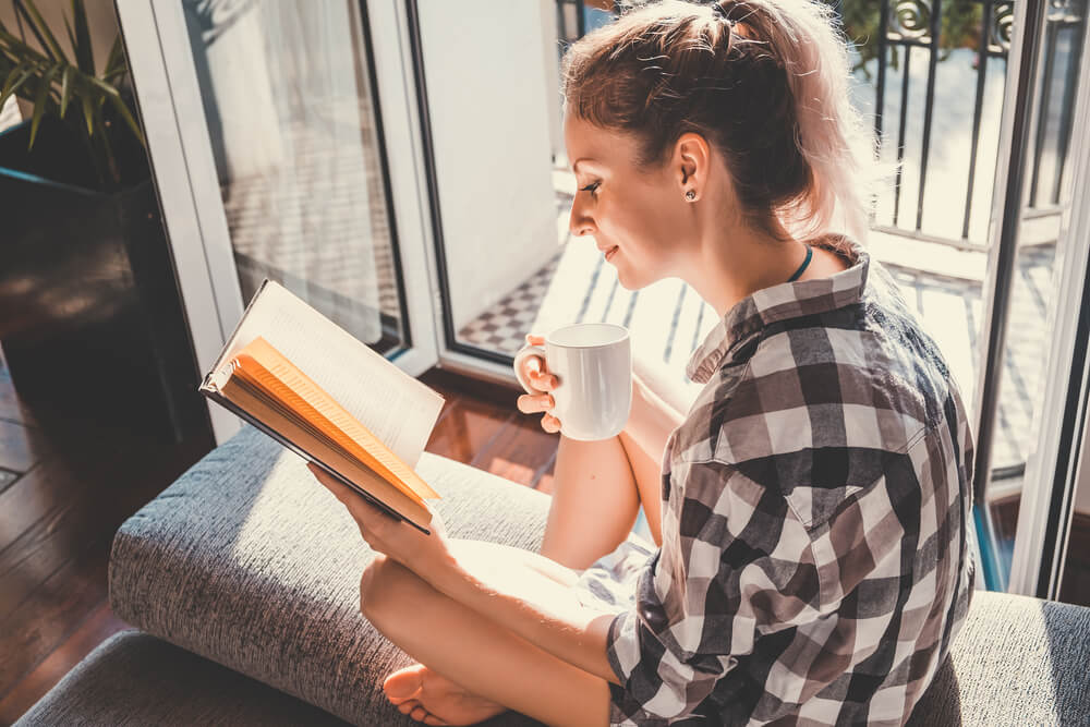 Young pretty woman sitting and reading a book