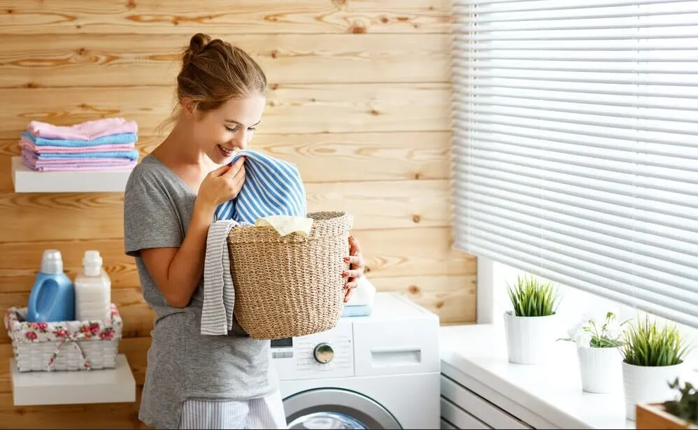 I Want to Be a Housewife: 7 Reasons Why This is the Right Decision 1 a Happy housewife woman in laundry room with washing machine