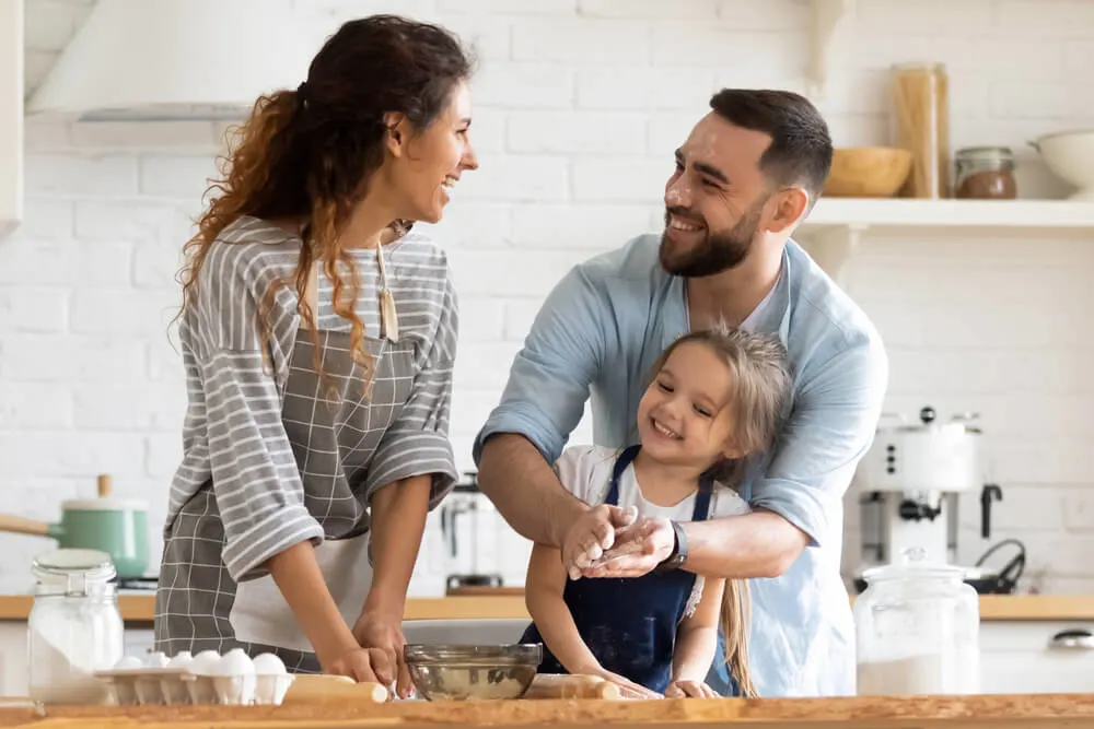 young family have fun doing bakery in kitchen together