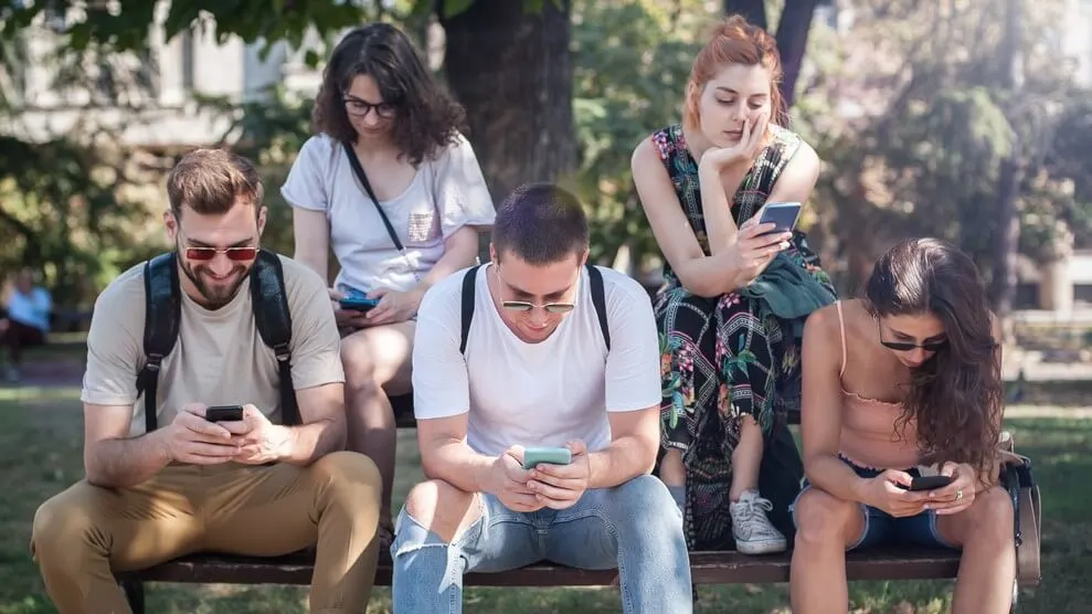 Group of friends using smartphones together