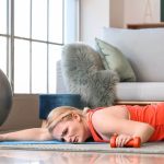 Exhausted woman with excess weight lying on floor after training at home
