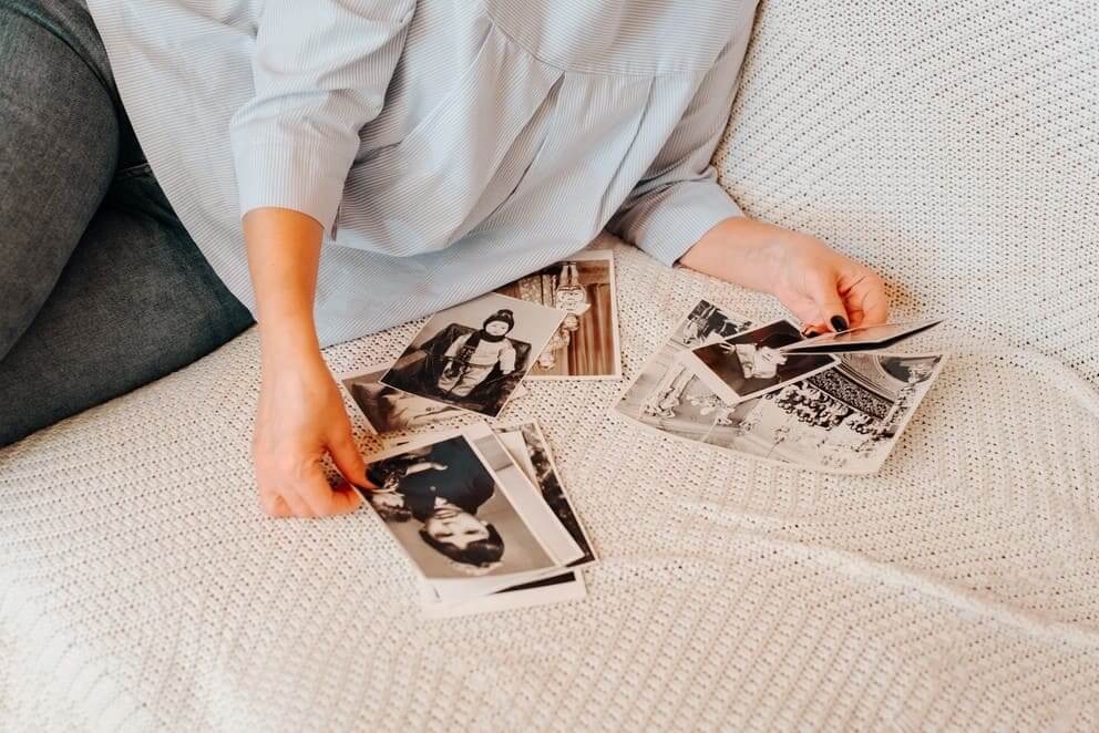 woman looking at her retro photographs, nostalgic for childhood