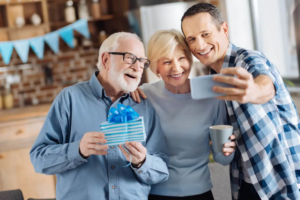 Cheerful young man taking selfies with his elderly parents