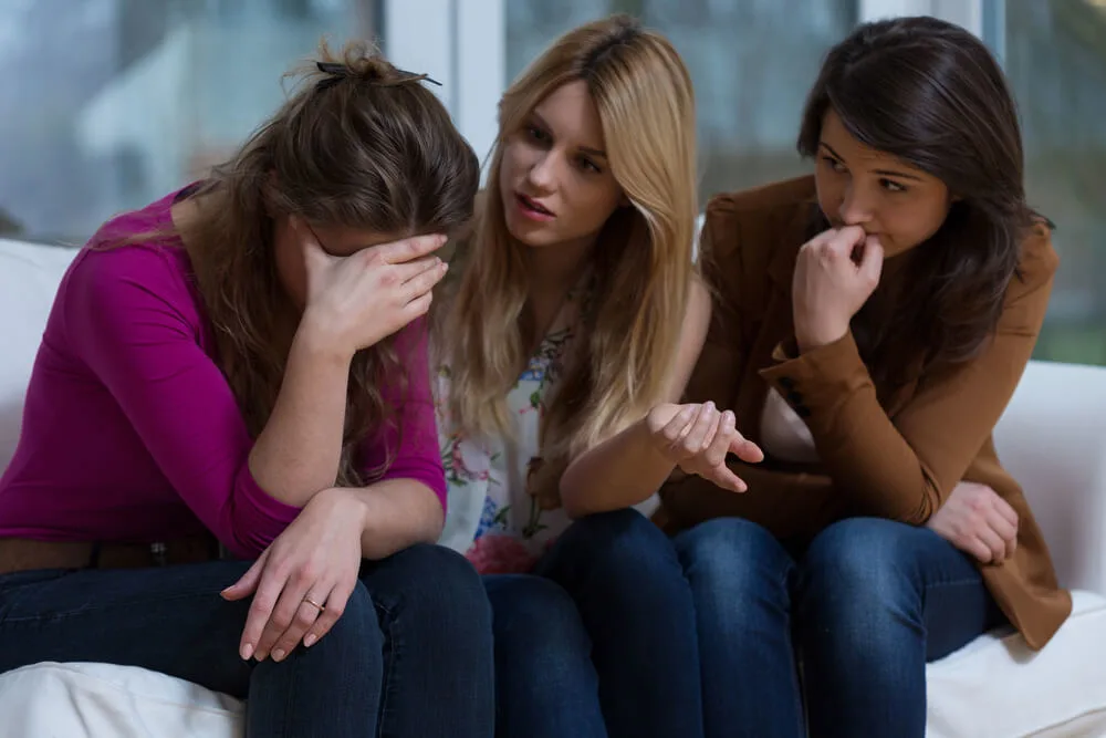 Two helpful girls talking with broke down friend