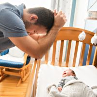 Tired father with upset baby