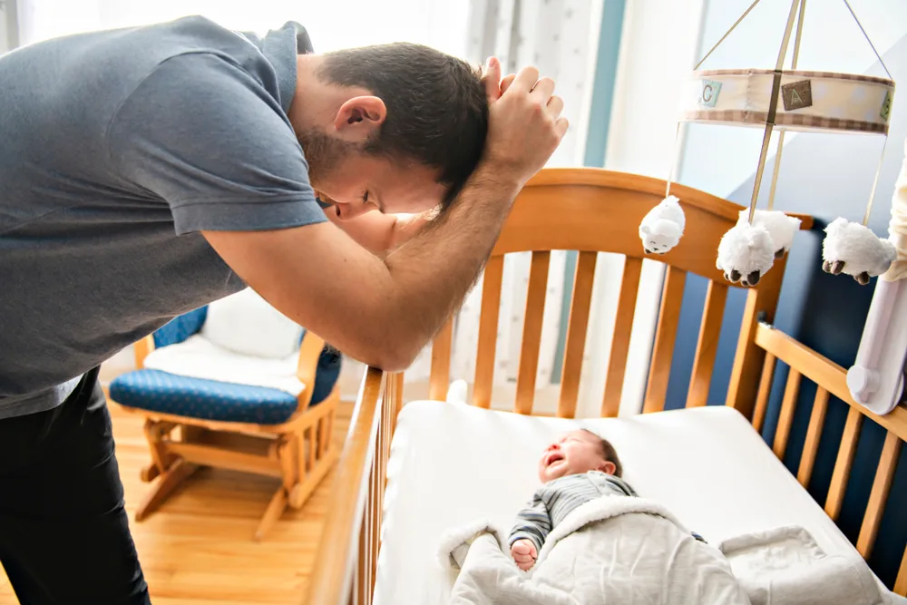 Tired father with upset baby