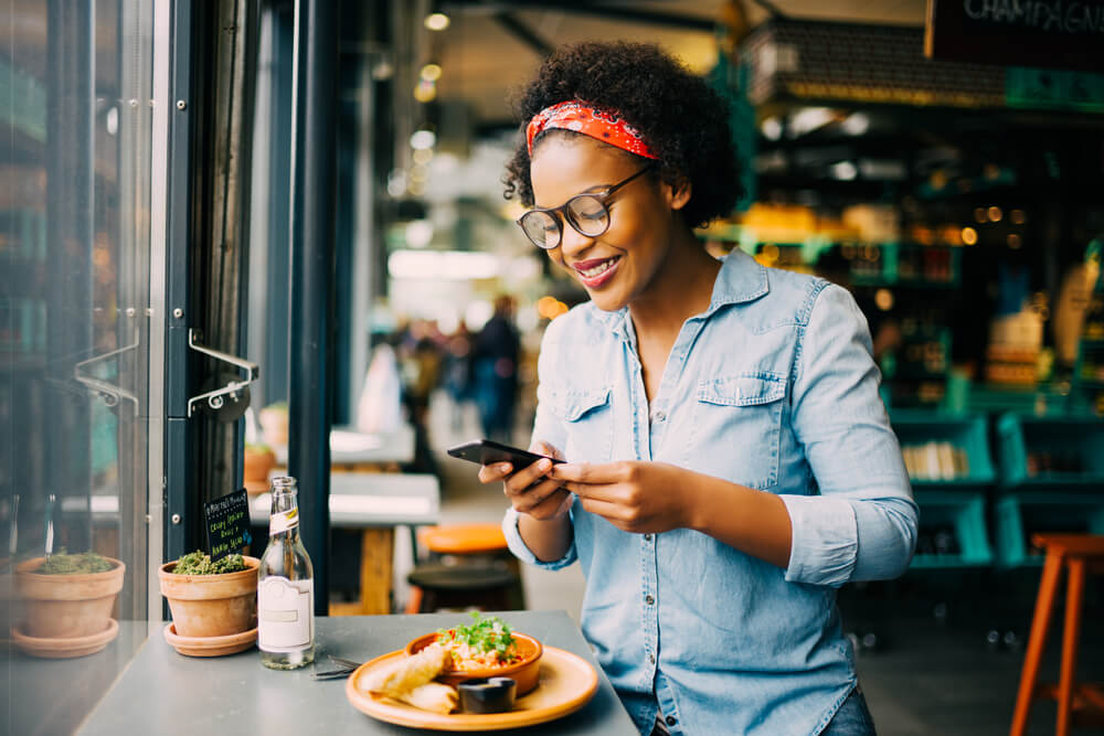 Woman smiling while sitting alone in a restaurant