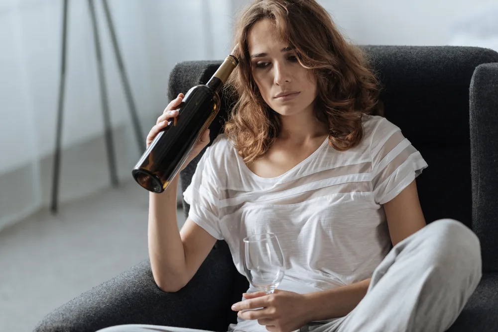 Depressed beautiful woman drinking wine