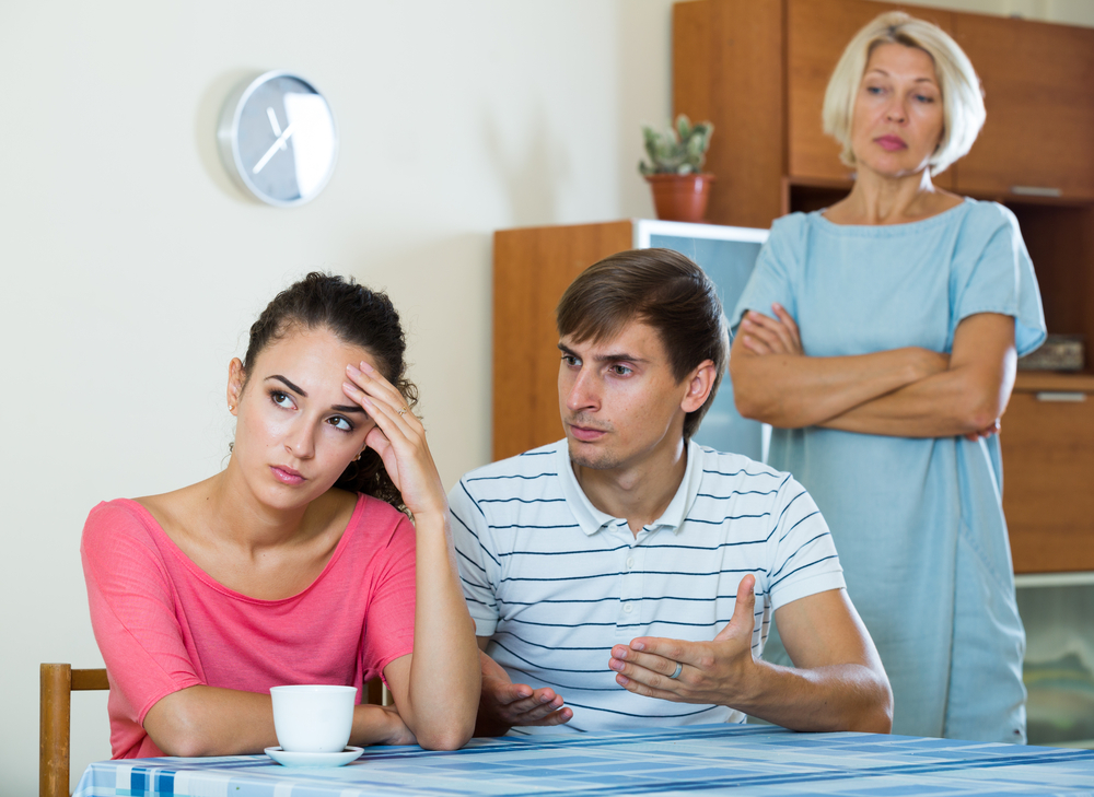 Offended young woman listening to rebukes from mother and husband