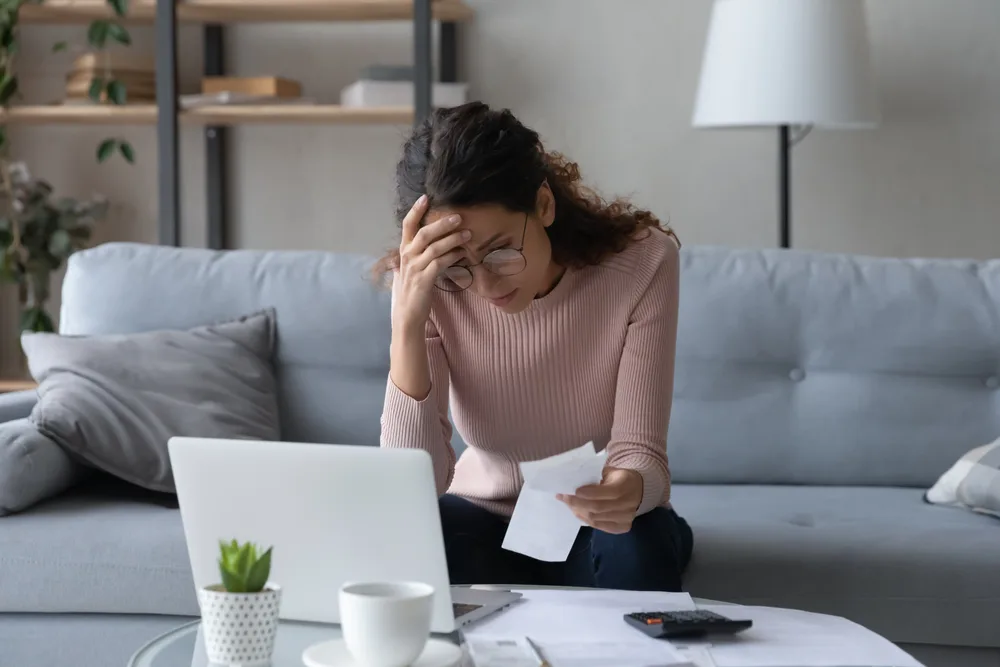 How to Stop Thinking About Lost Money? 5 Ways 1 Unhappy young woman in glasses feeling stressed about lost money